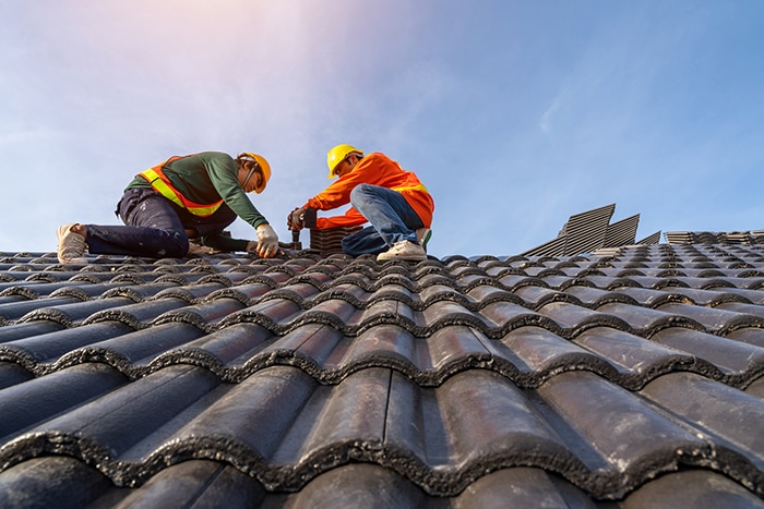 Teamwork of roofer workers in protective uniform wear and